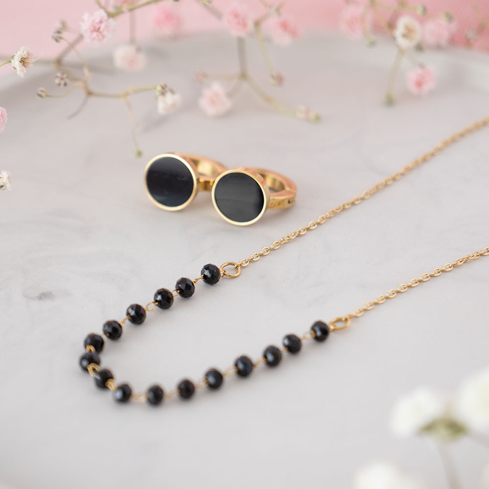 Komplet naszyjnik zdobiony czarnymi koralikami i kolczyki z czarnym oczkiem